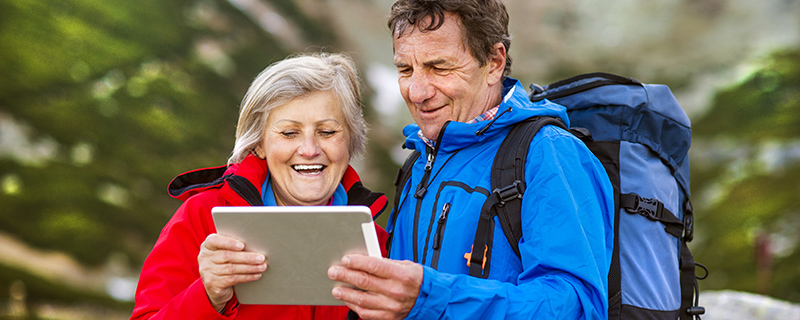 Par som vandrar i fjällen på en vandringsresa med ipad.